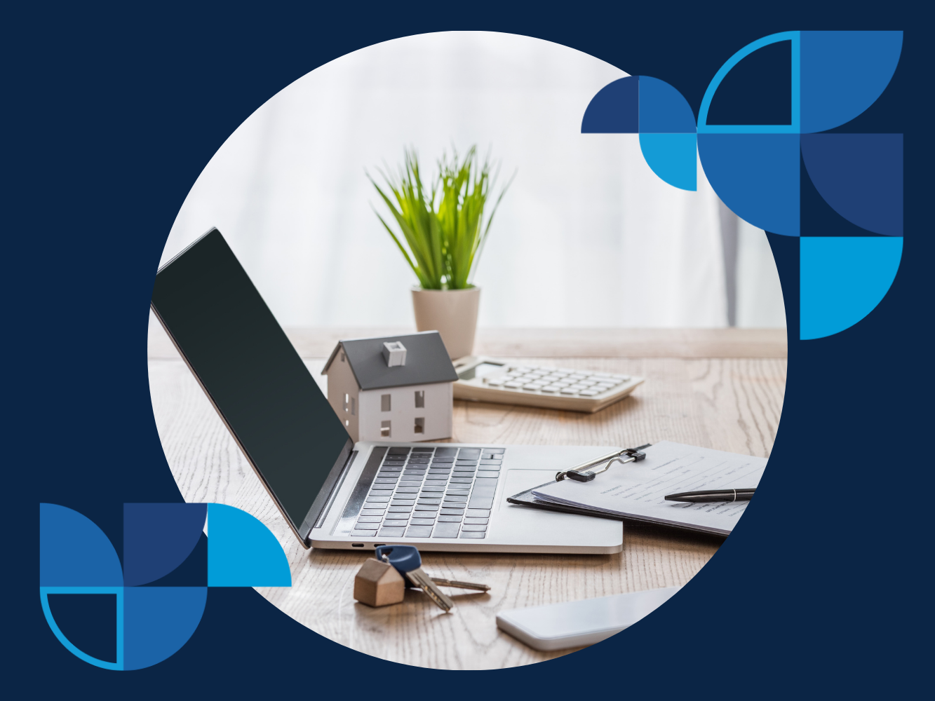 A silver laptop computer with a black open screen sits on a light brown wooden table. To the right of the laptop is a small, unfinished wooden model house with a pitched roof.